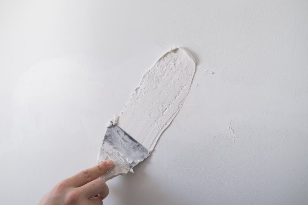 repairing walls with putty and spatula